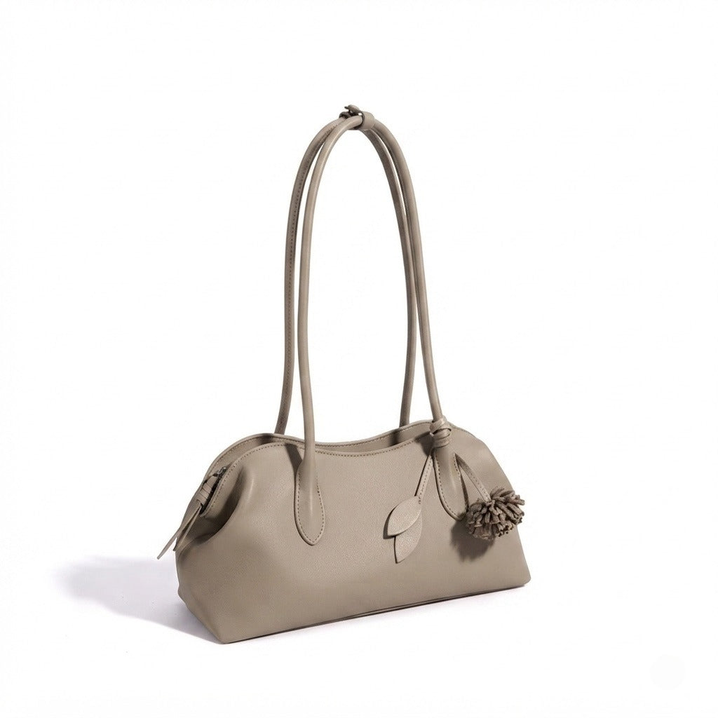Bolso clutch curvo de piel con charm