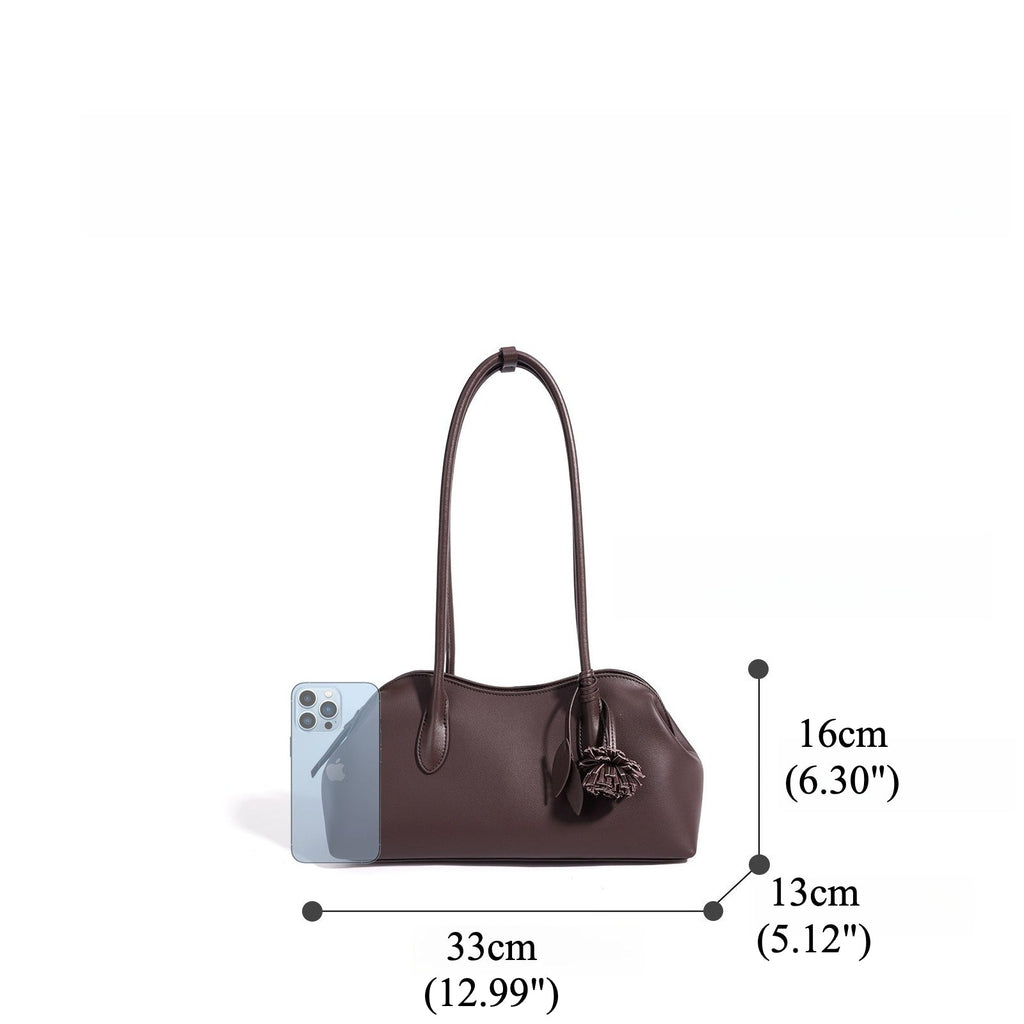 Bolso clutch curvo de piel con charm