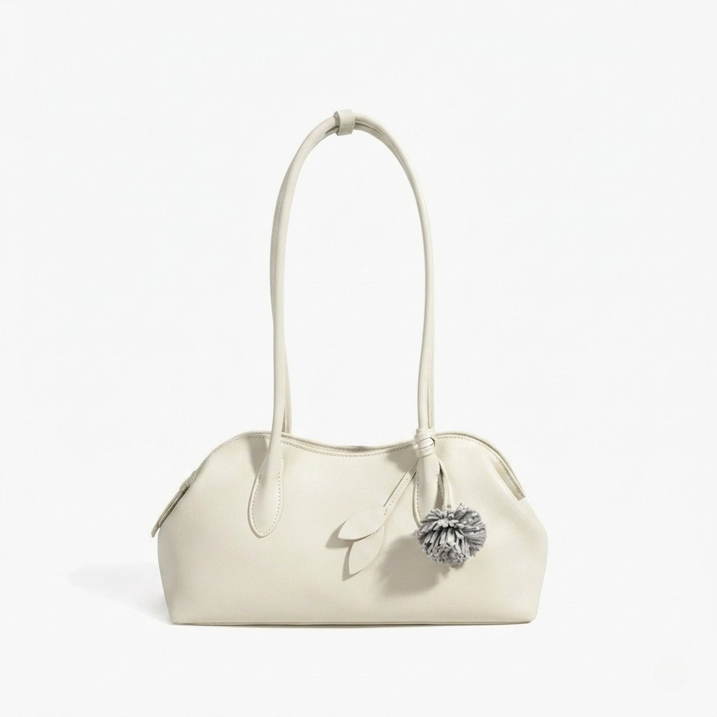 Bolso clutch curvo de piel con charm