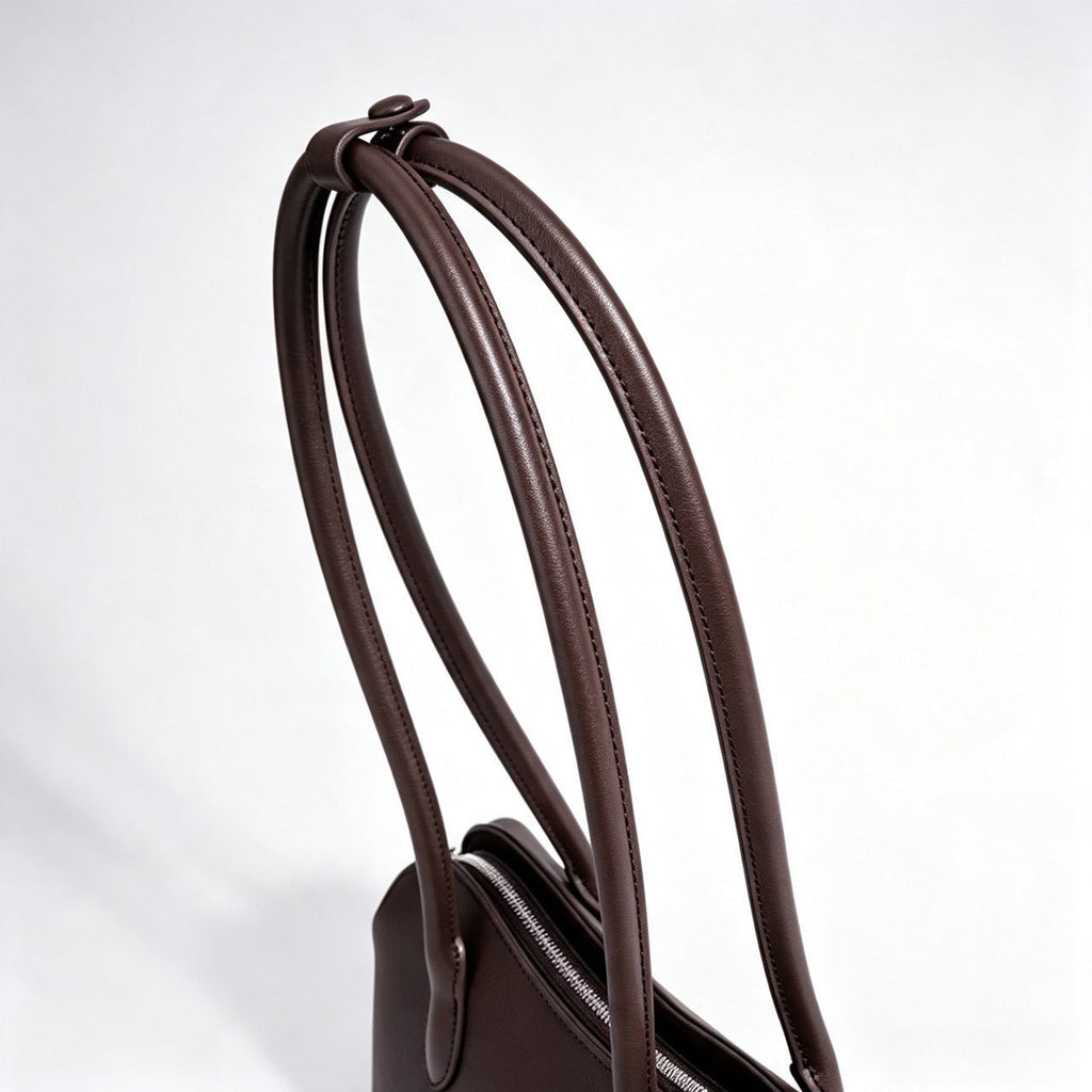 Bolso clutch curvo de piel con charm