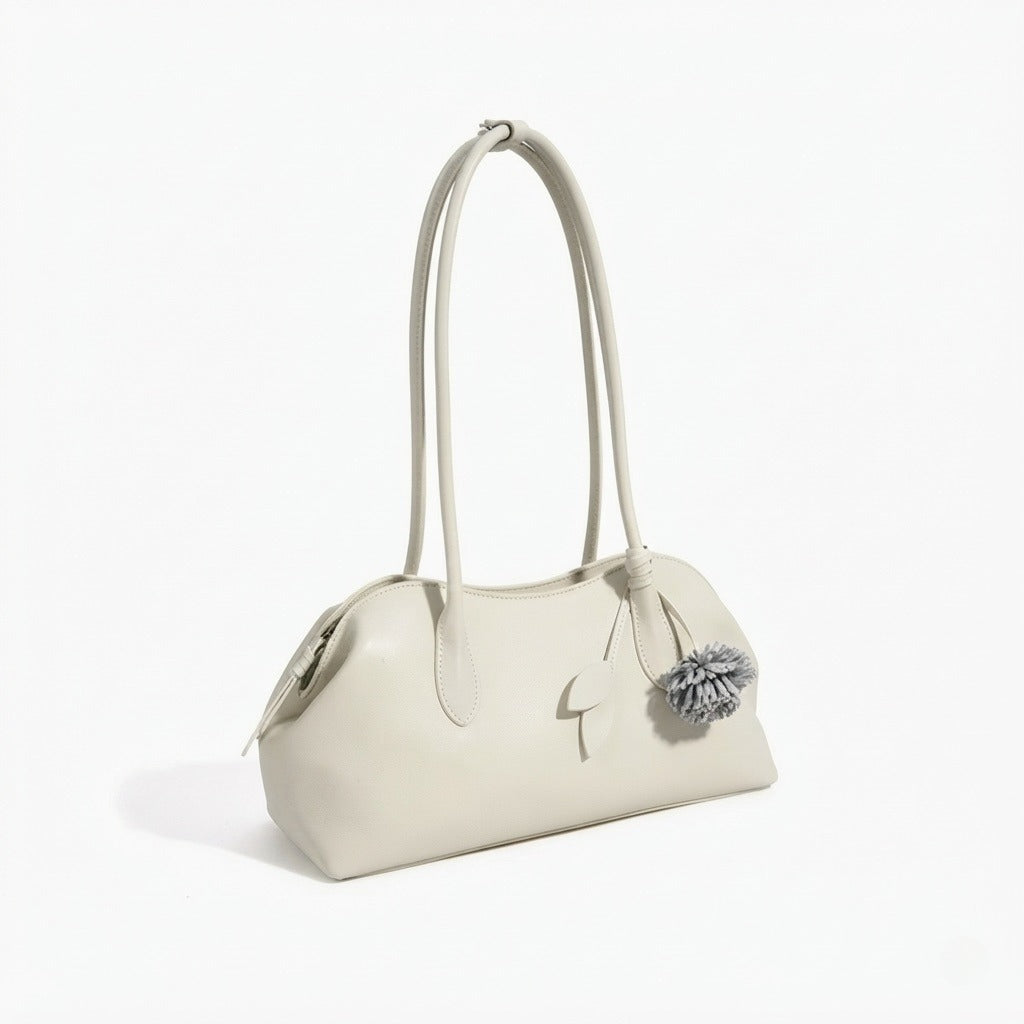 Bolso clutch curvo de piel con charm