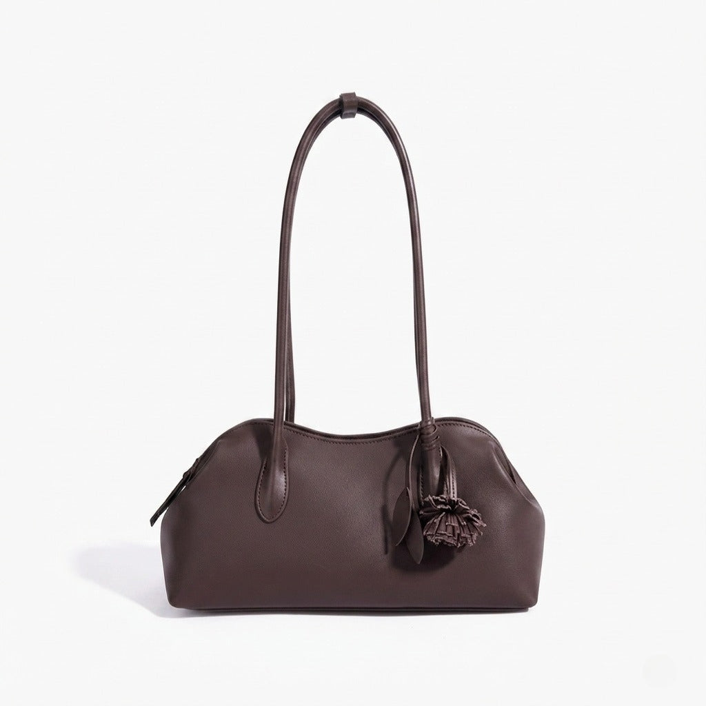 Bolso clutch curvo de piel con charm