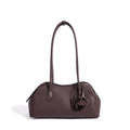 Bolso clutch curvo de piel con charm