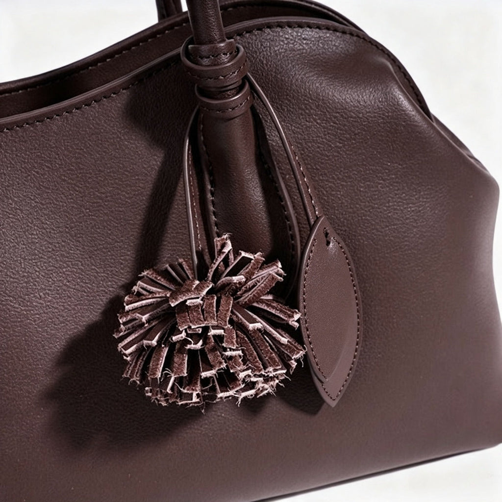 Bolso clutch curvo de piel con charm