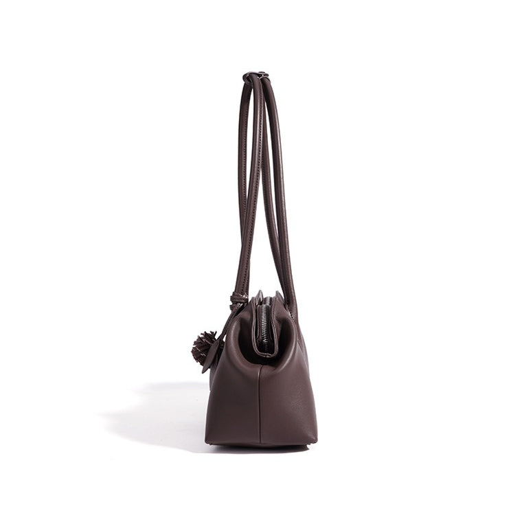Bolso clutch curvo de piel con charm
