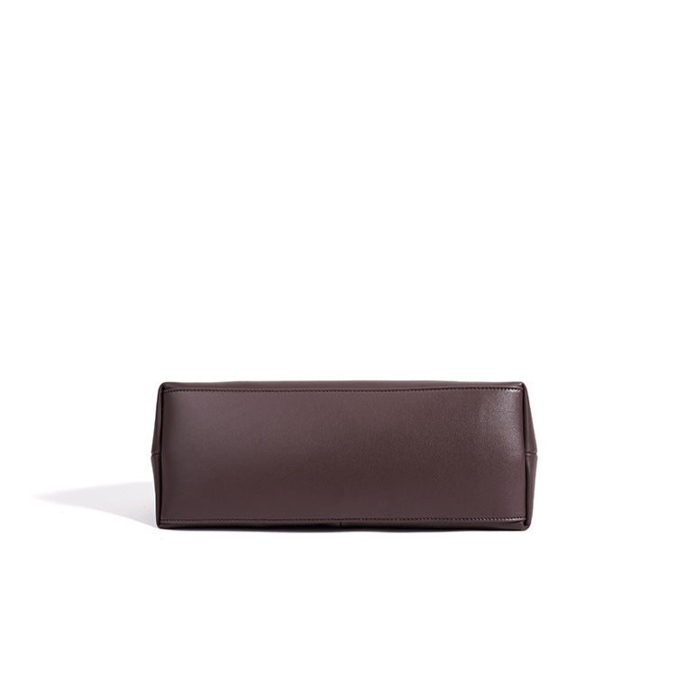 Bolso clutch curvo de piel con charm