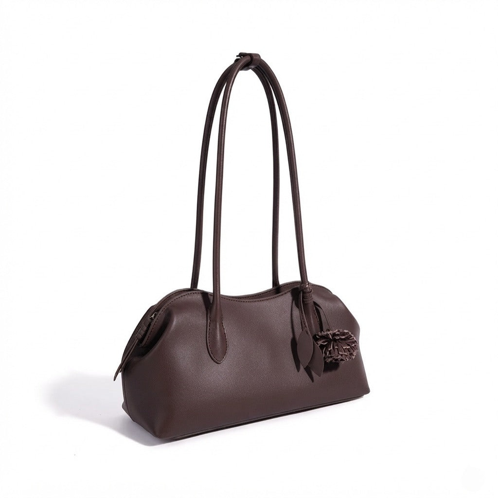 Bolso clutch curvo de piel con charm