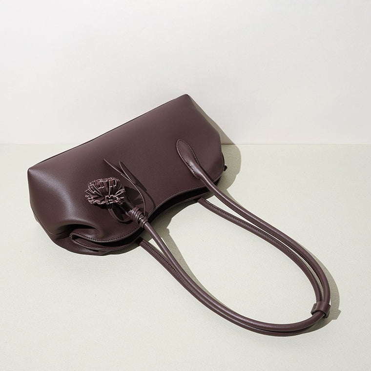 Bolso clutch curvo de piel con charm