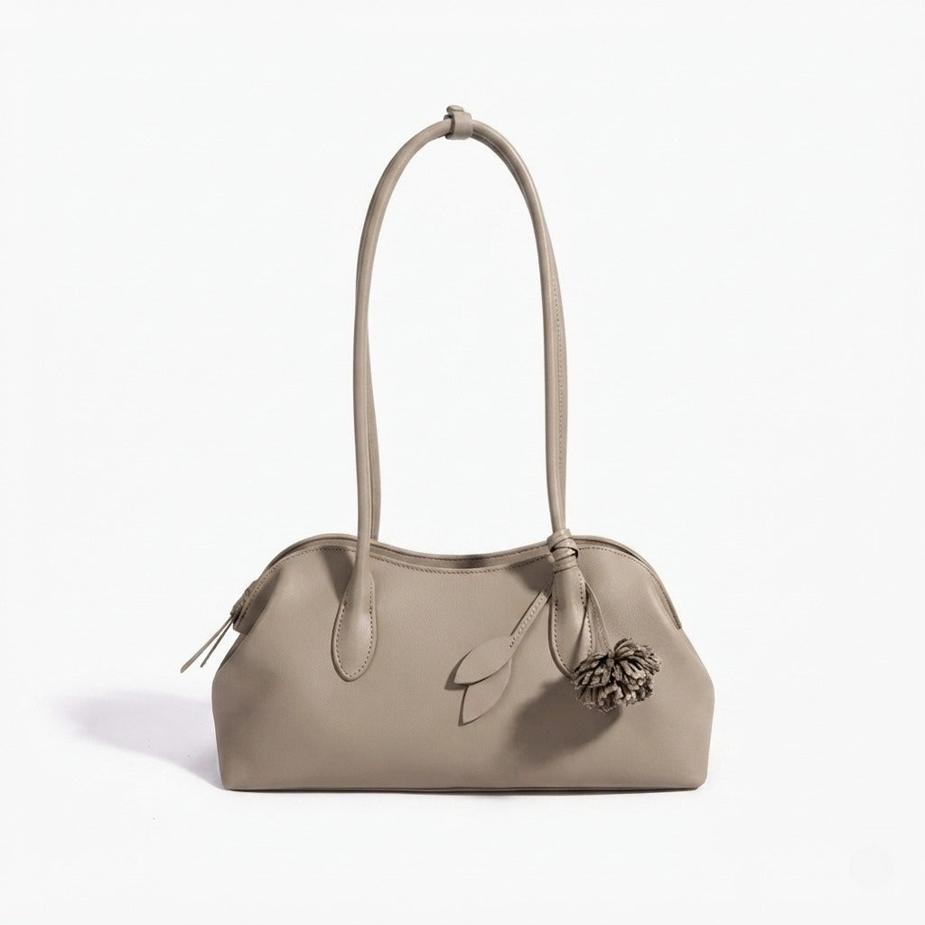 Bolso clutch curvo de piel con charm